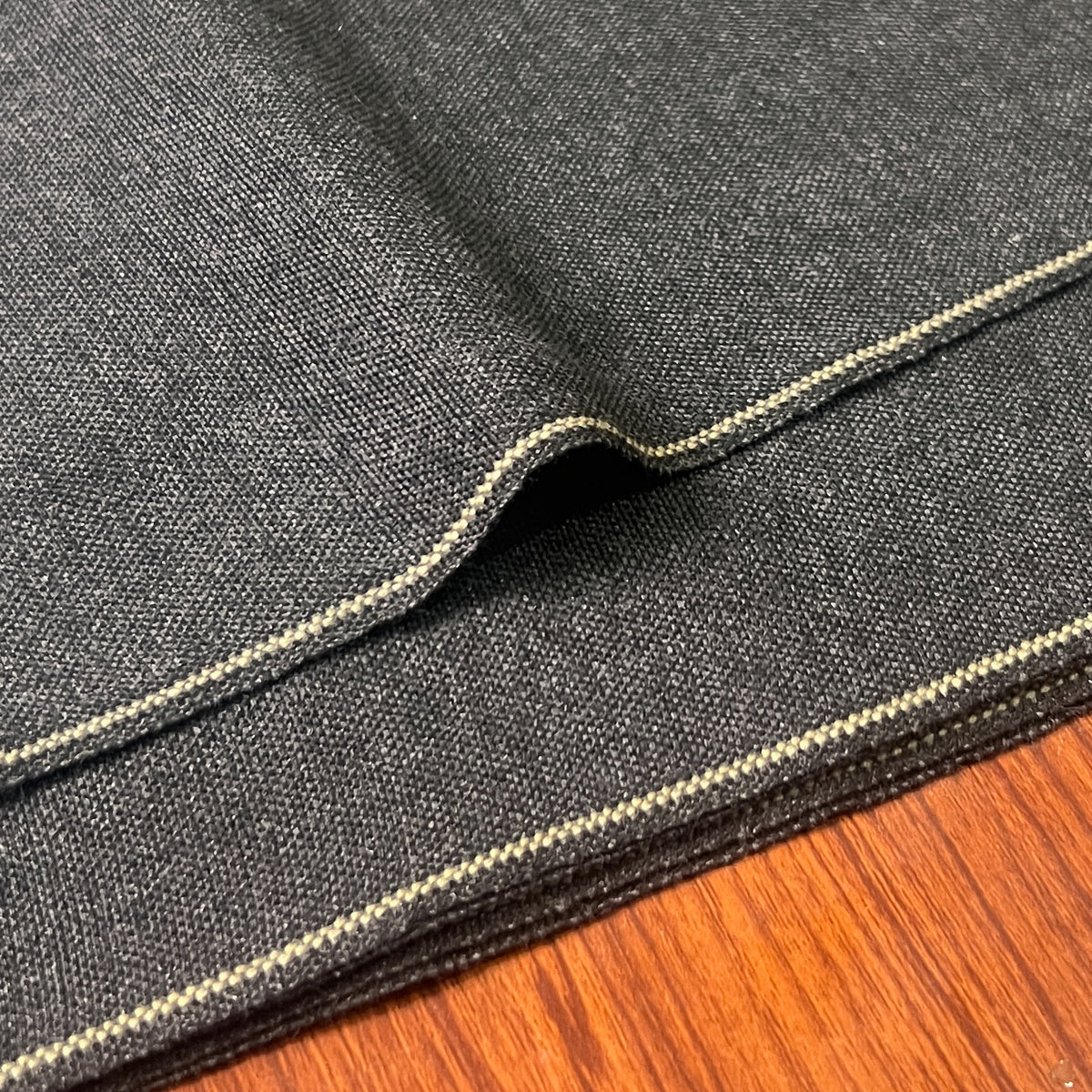 Close-up of dark Malaysian woollen unstitched winter suit fabric with textured weave